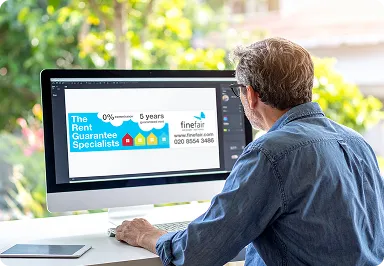 A man sitting at a computer designing a billboard
