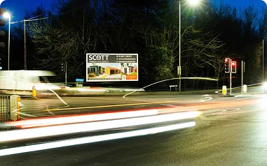 A roadside billboard at a busy intersection