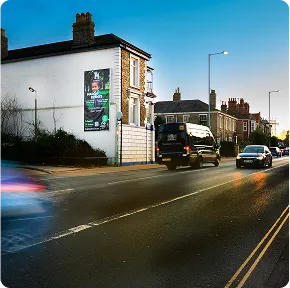 A roadside billboard on a building in a busy urban area